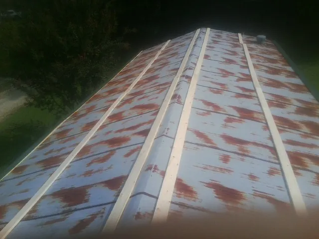 Rusted metal roof panels with new wood purlins before replacement — Storm Damage Roof Repair in Lawrenceville by Roofing Brothers