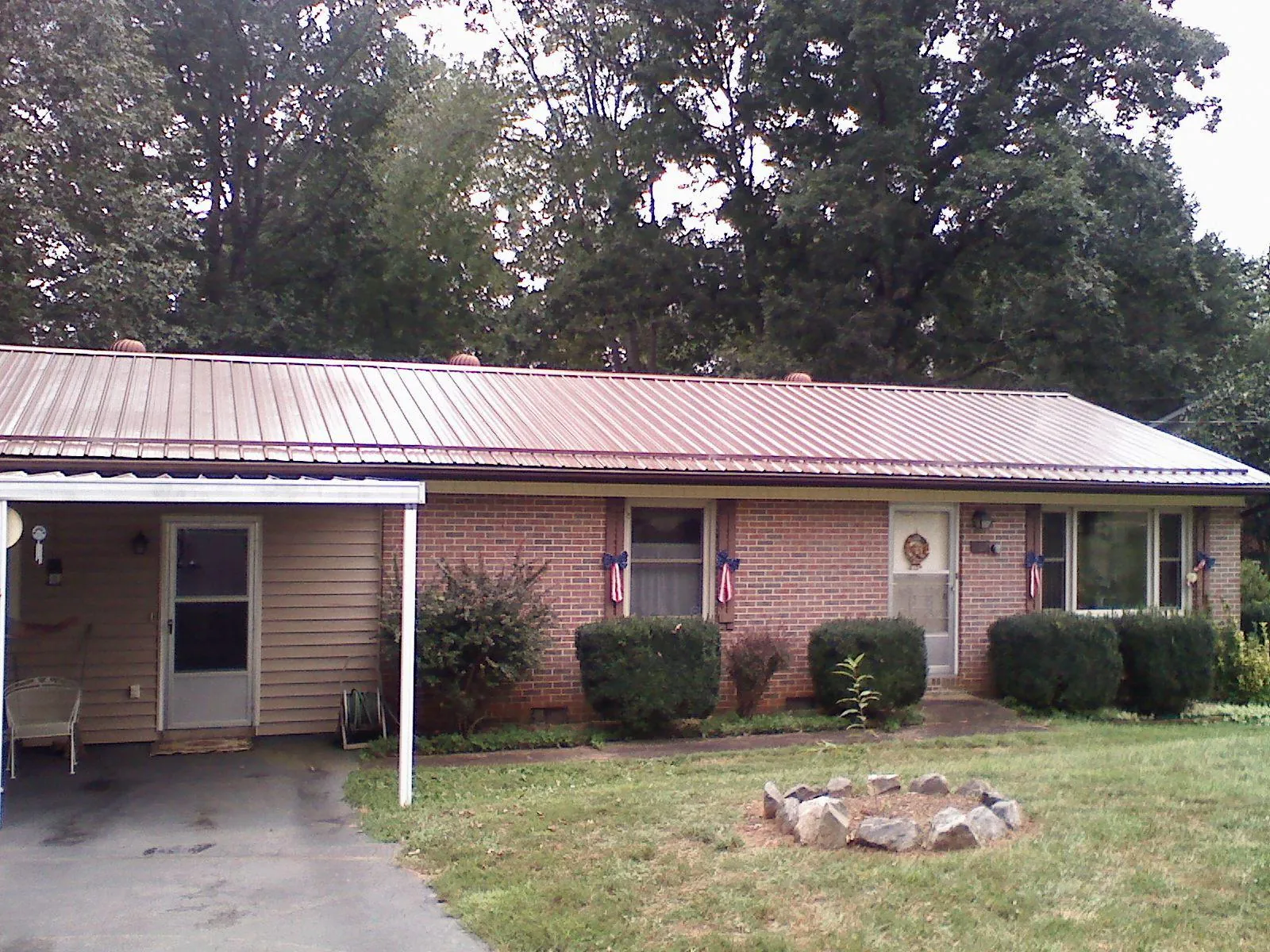 Bronze metal roof and carport on a brick ranch home — Roof Repair work by our crew in Lawrenceville